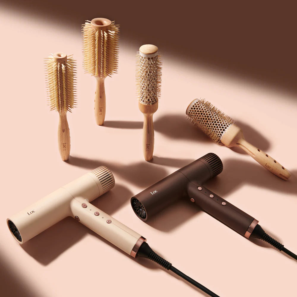 Set of hairbrushes and hairdryers on a beige background
