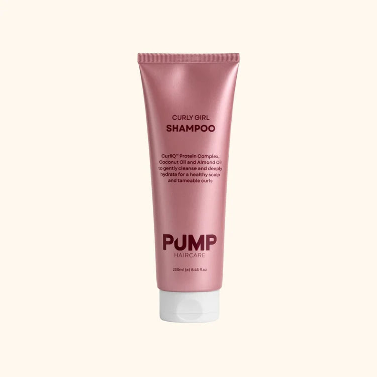 Pink shampoo tube labeled 'Curly Girl Shampoo' by Pump Haircare on a white background