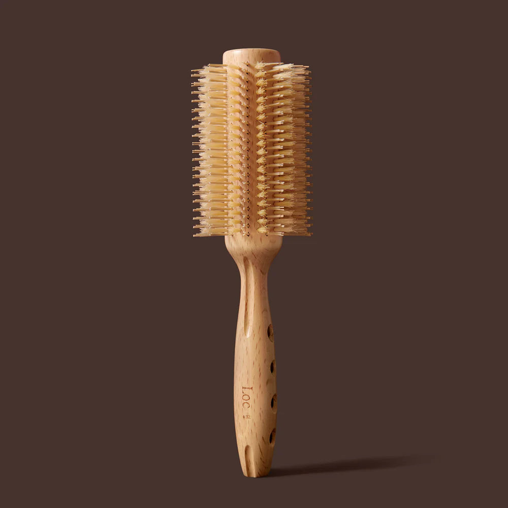 Wooden hairbrush with bristle head on a brown background