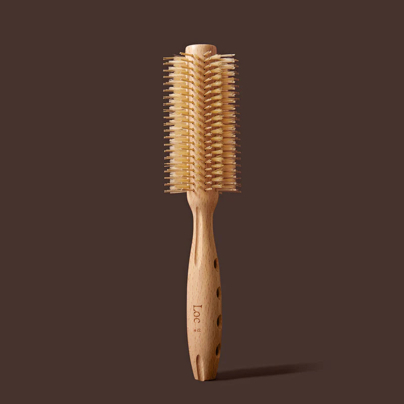 Wooden hairbrush with bristle head on a brown background