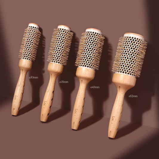 Four wooden hairbrushes with different bristle densities on a brown background