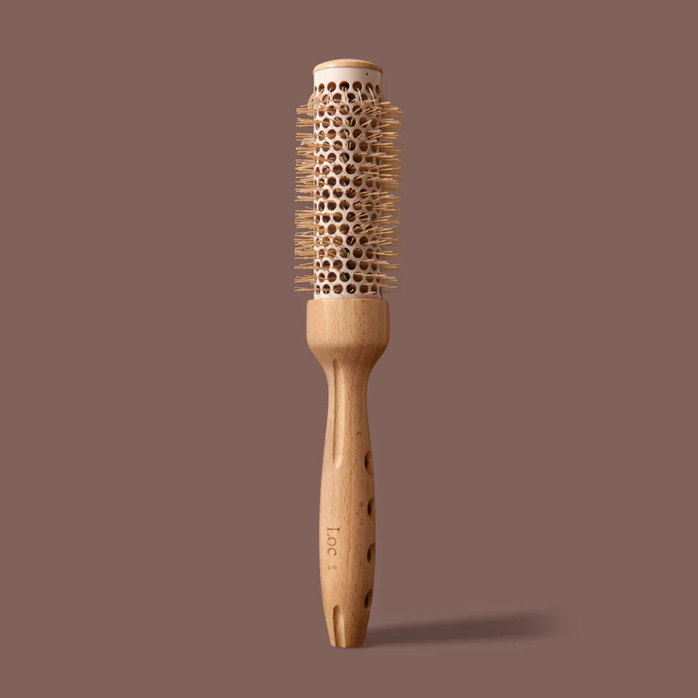 Wooden hairbrush with round bristle head on a brown background