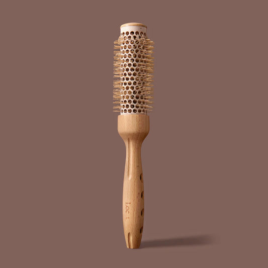 Wooden hairbrush with round bristle head on a brown background
