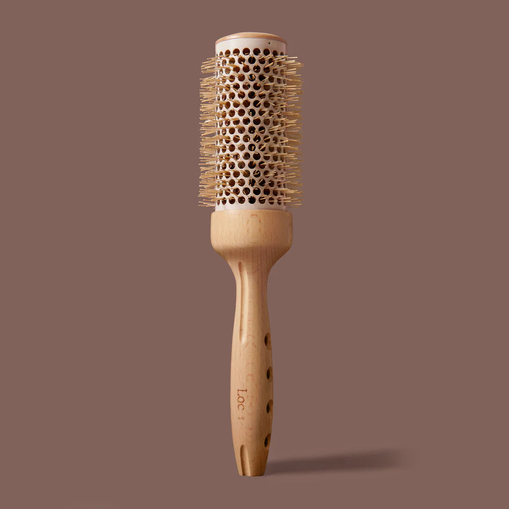 Wooden hairbrush with bristle head on a brown background