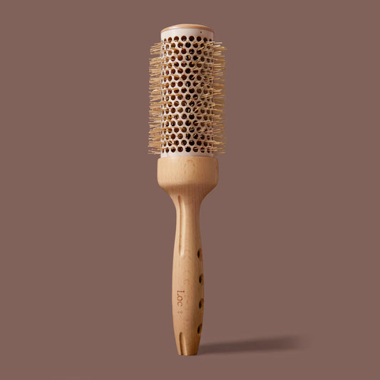 Wooden hairbrush with bristle head on a brown background