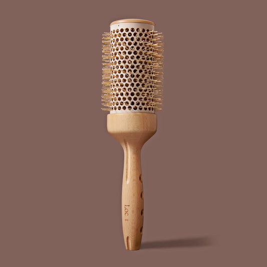 Wooden hairbrush with bristle head on a brown background