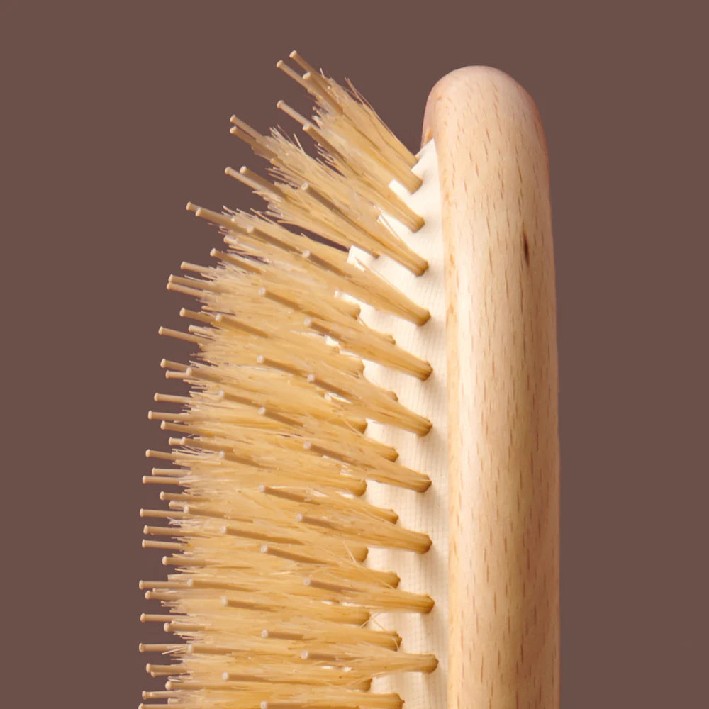 Wooden hairbrush with bristles on a brown background