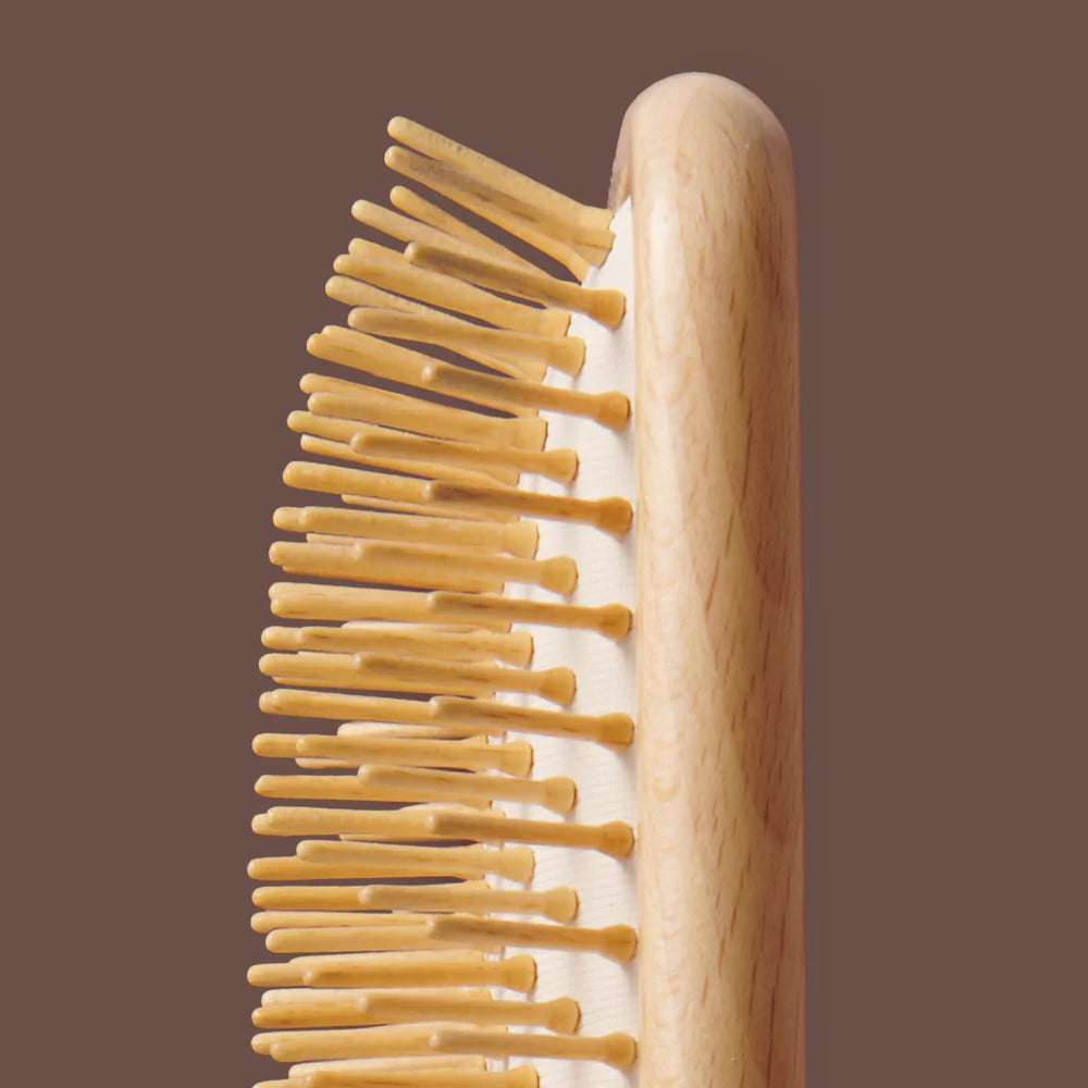 Wooden hairbrush with wooden handle on a brown background
