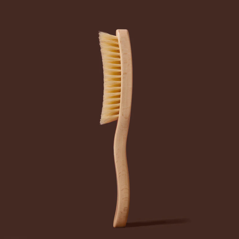 Wooden brush with bristles on a brown background