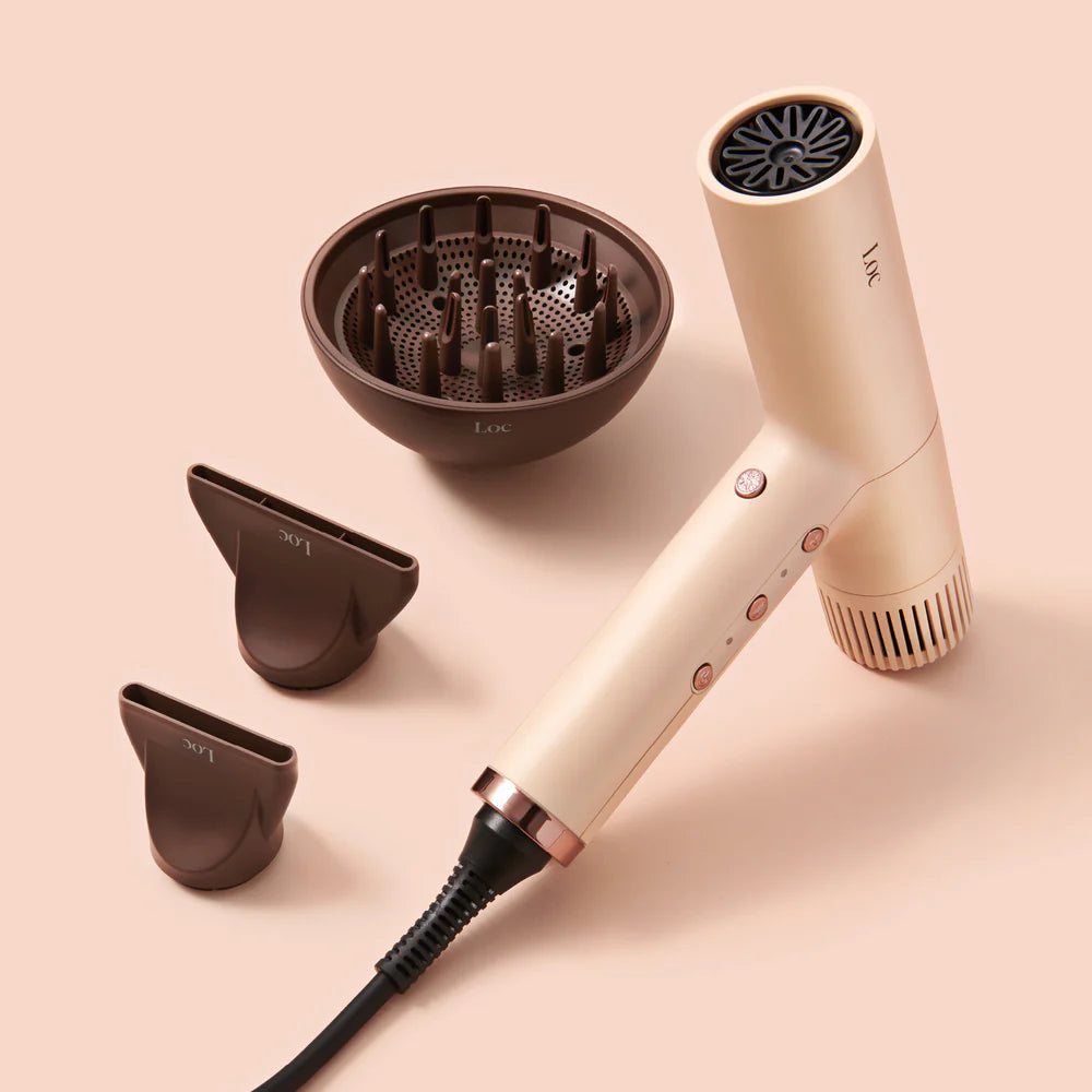 Beige hair dryer with attachments on a beige background