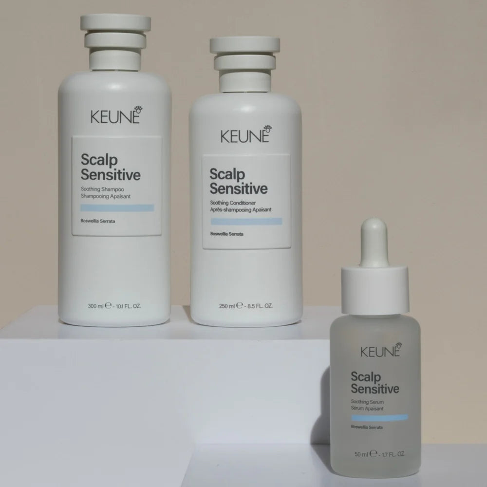Three bottles of Keune Scalp Sensitive hair care products on a white surface with a beige background.