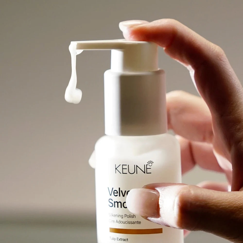 Hand holding a Keune hair care product with a close-up of the pump.