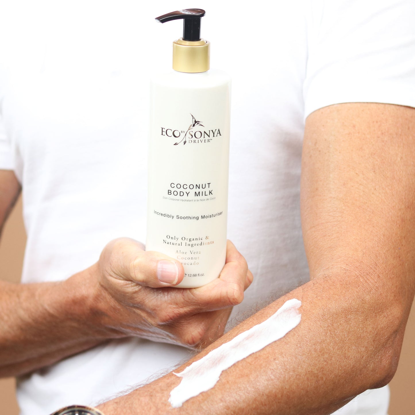 eco tan coconut body milk held in hand